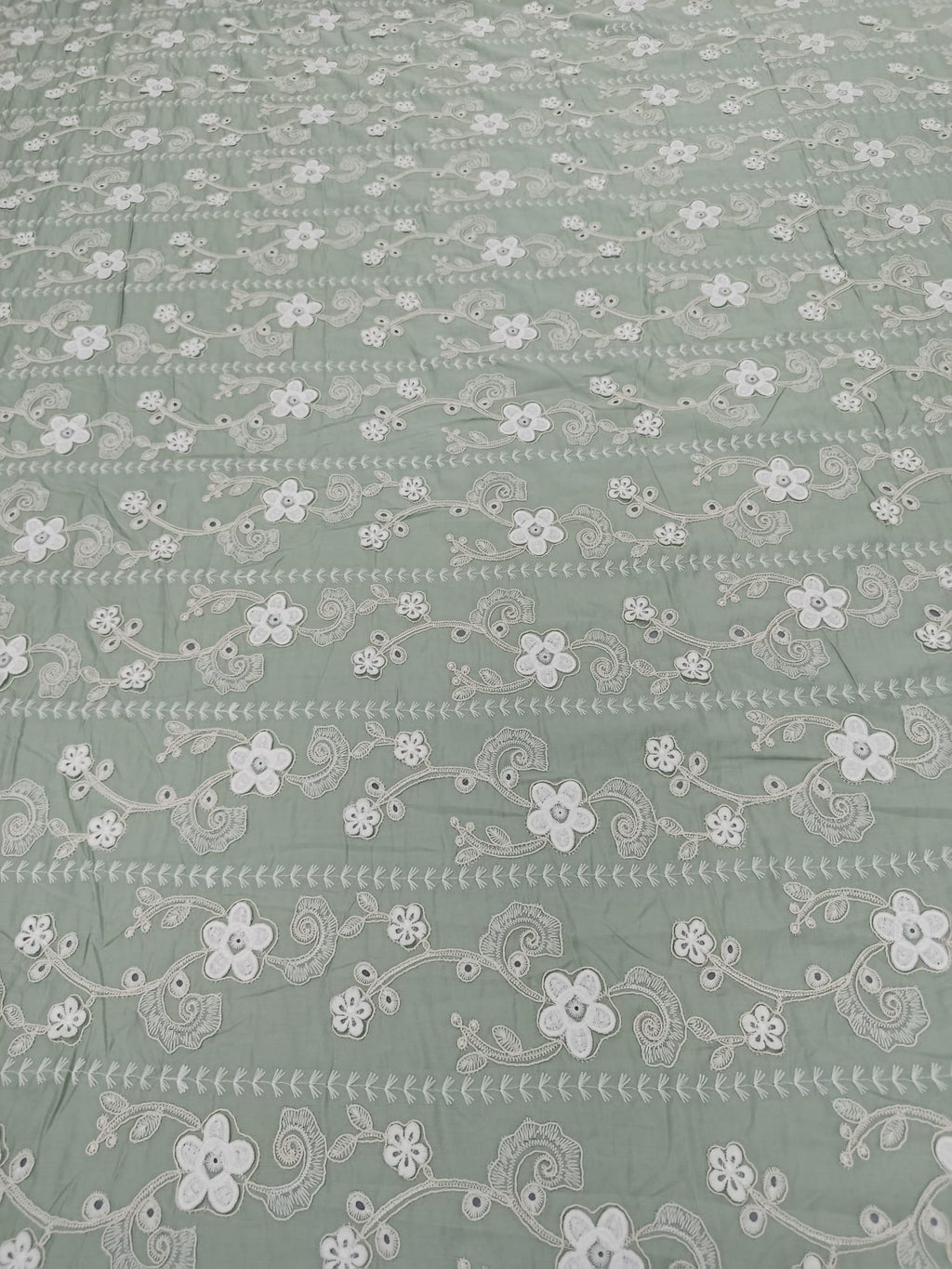 Detaliu al broderiei 3D pe material din bumbac Lyocell verde salvie
