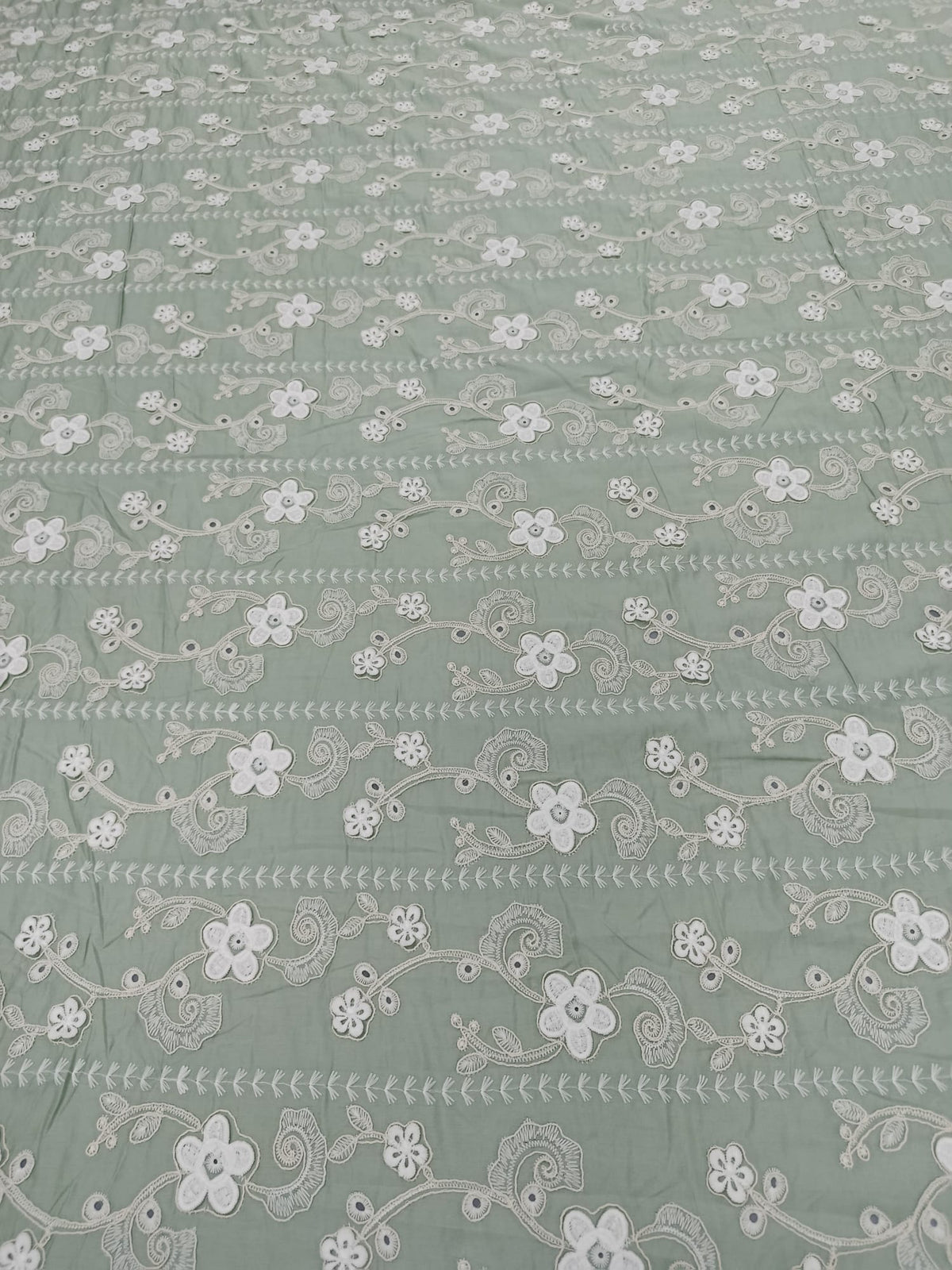 Detaliu al broderiei 3D pe material din bumbac Lyocell verde salvie