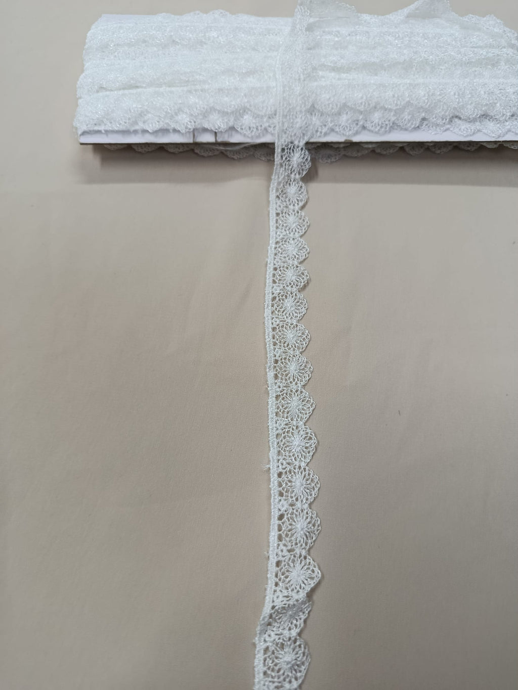Prim-plan dantelă decorativă cu margini ondulate fine, disponibilă în alb și negru, ideală pentru rochii, accesorii și decorațiuni textile