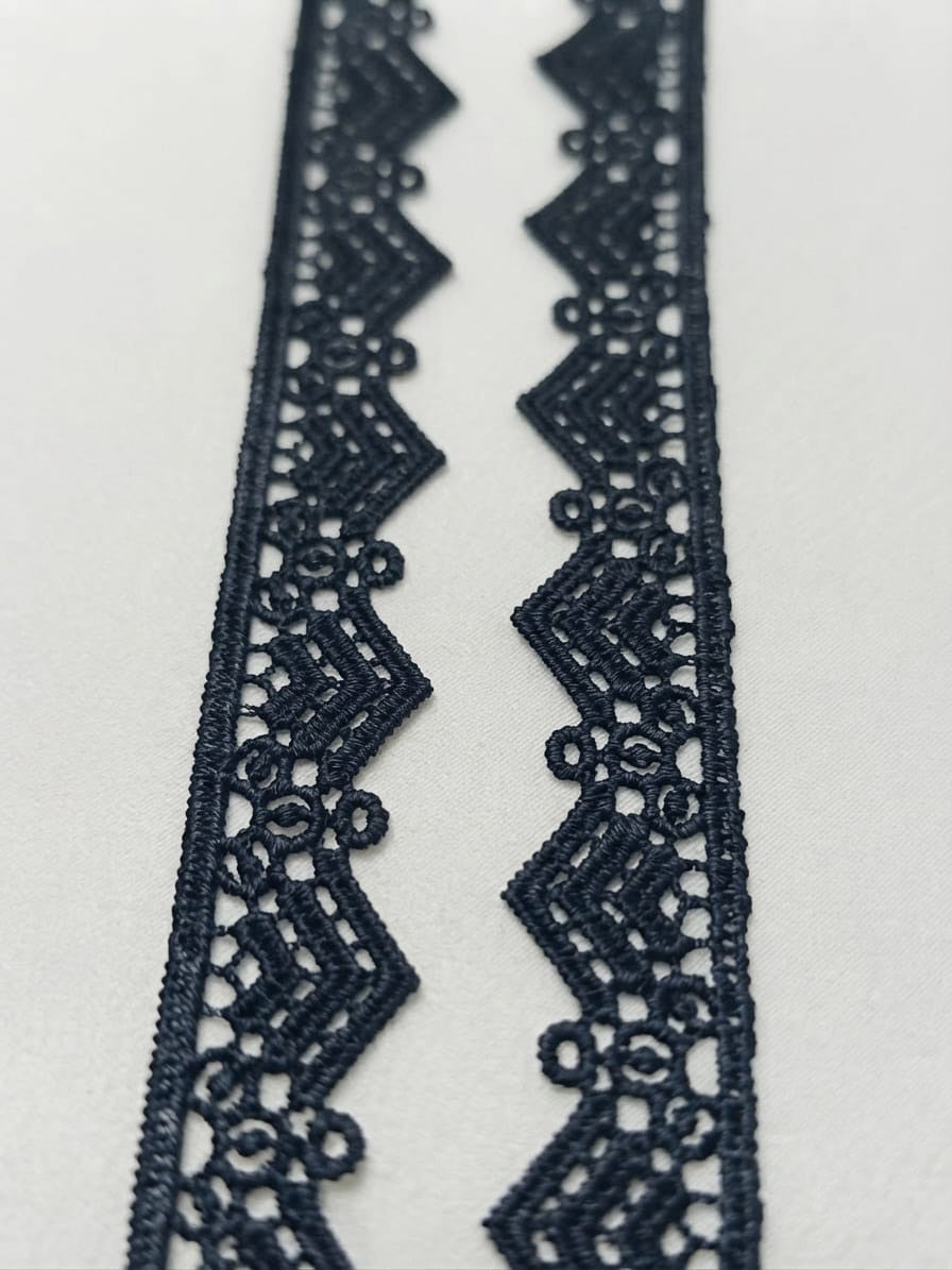 Detaliu dantelă decorativă neagră cu model de colțuri, lățime 2 cm, livrată pe rolă de 15 yds.