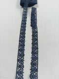 Detaliu dantelă neagră cu flori mici și margini ondulate, lățime 2 cm, ideală pentru croitorie, accesorii și decorațiuni textile.