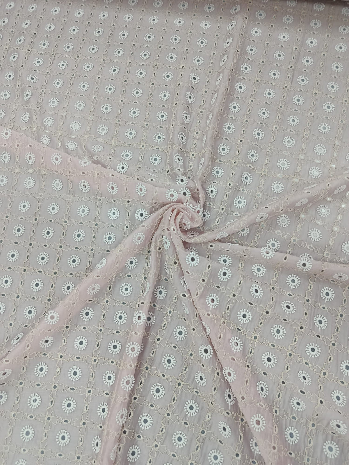 Prim-plan al broderiei sparte pe material Lyocell roz deschis