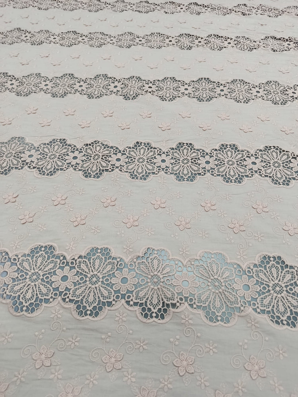 Detaliu al broderiei florale 3D pe bumbac roz pudrat de calitate premium