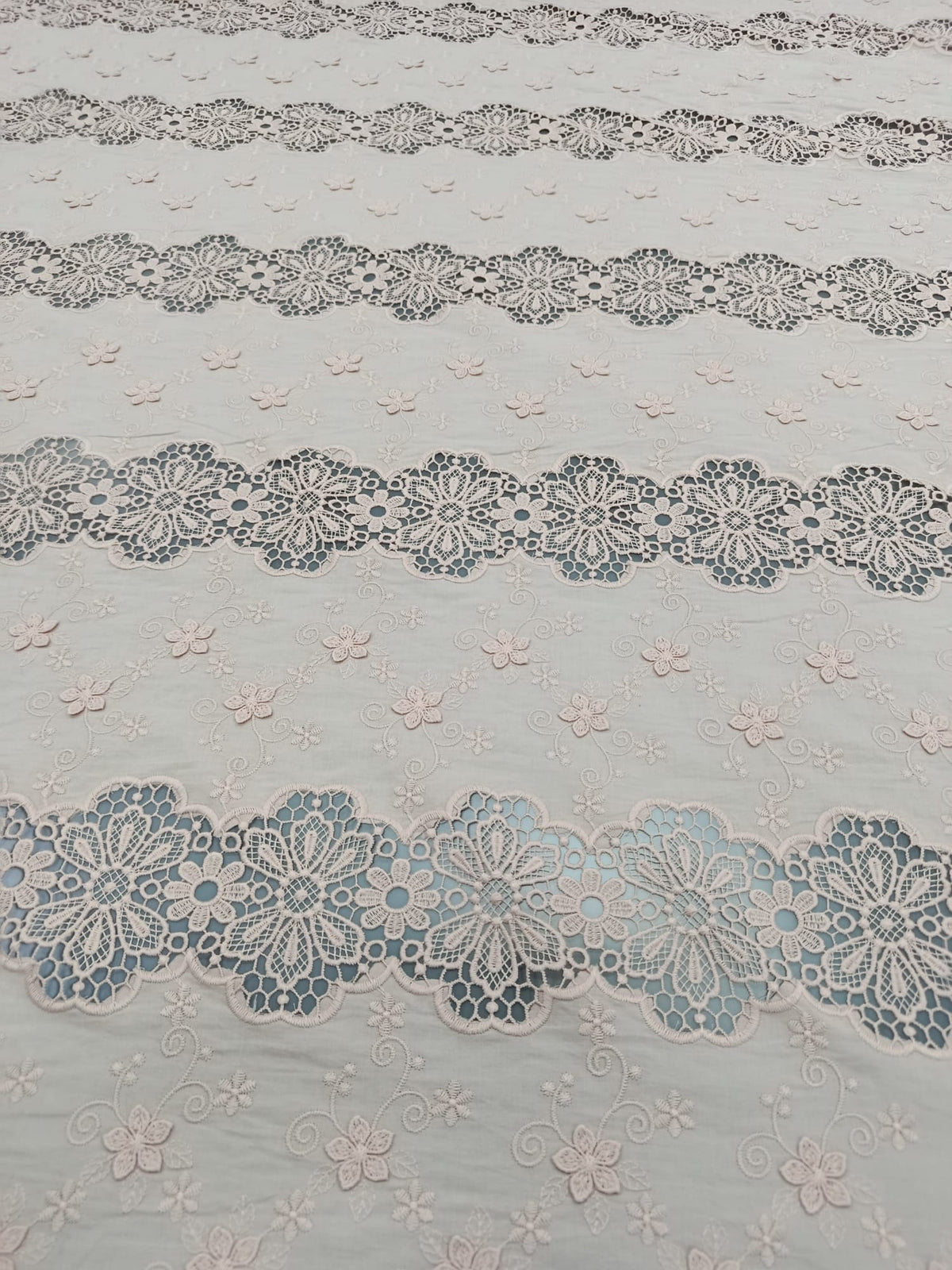Detaliu al broderiei florale 3D pe bumbac roz pudrat de calitate premium