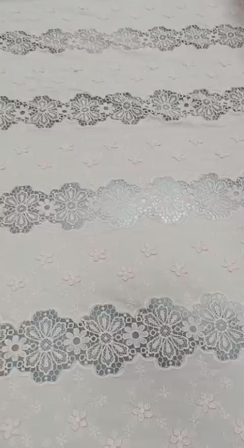 Detaliu al broderiei sparte și florilor 3D pe bumbac roz pudrat