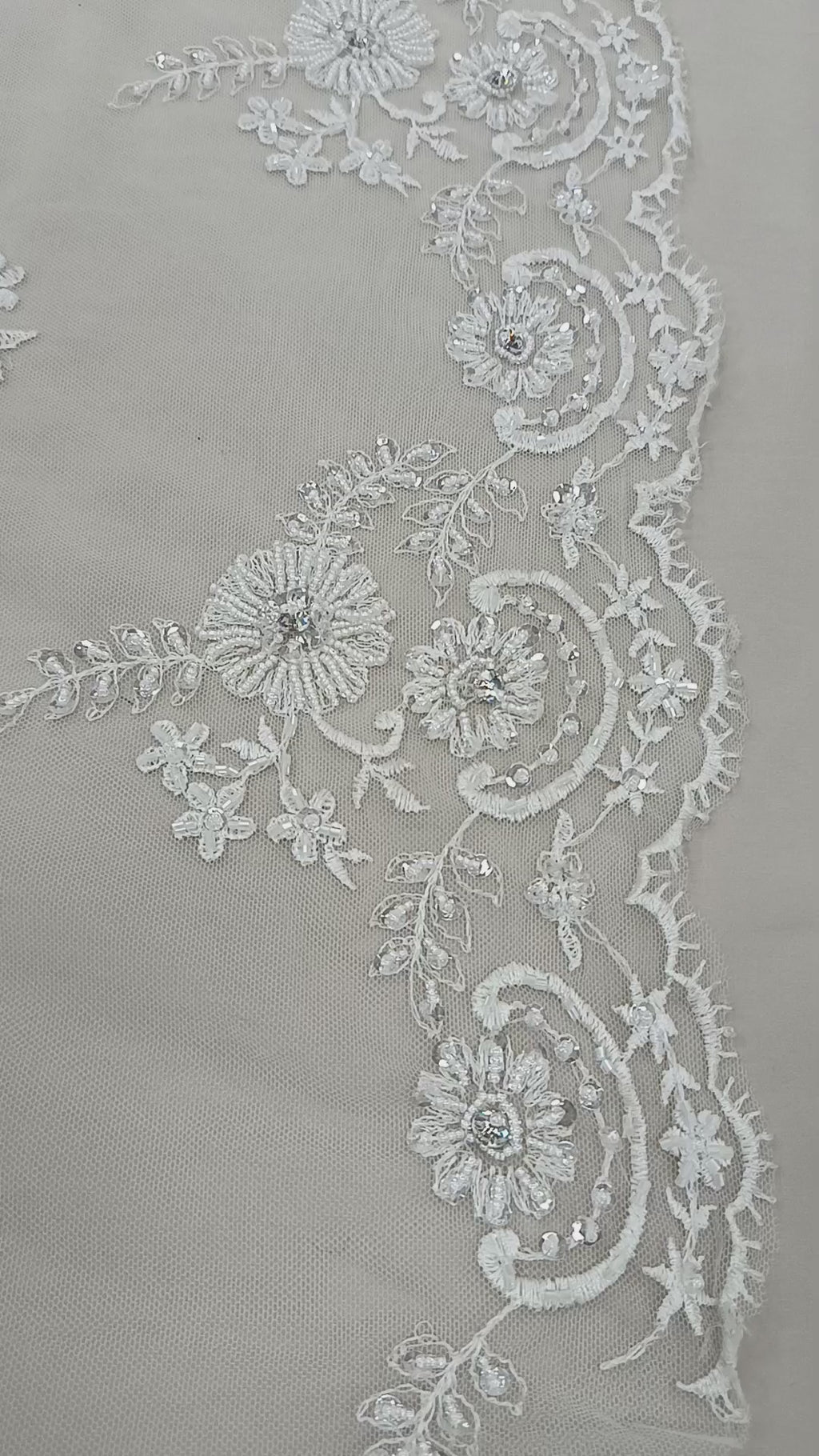 Prim-plan al florilor brodate cu cristale și paiete pe tull alb elegant