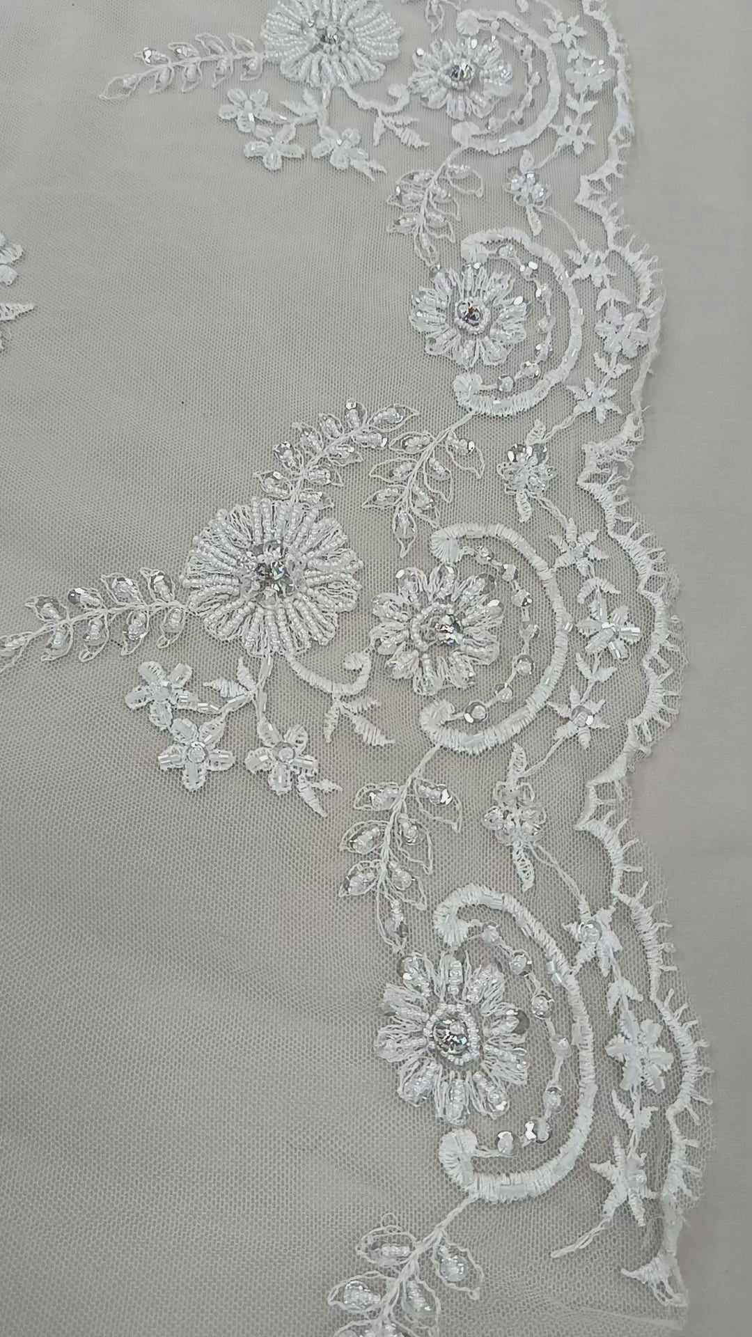 Prim-plan al florilor brodate cu cristale și paiete pe tull alb elegant