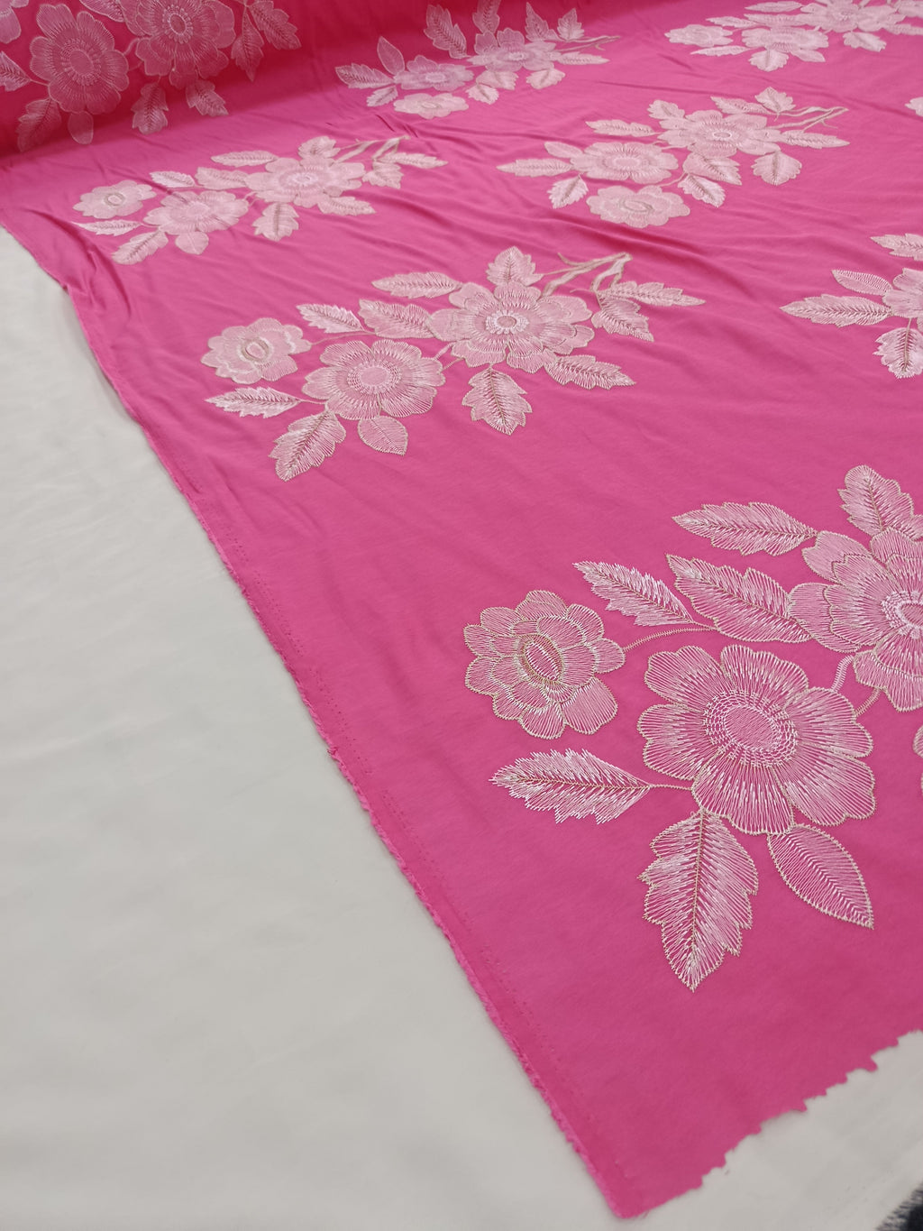 Model decorativ cu broderie și fir metalic roz pe țesătură premium.