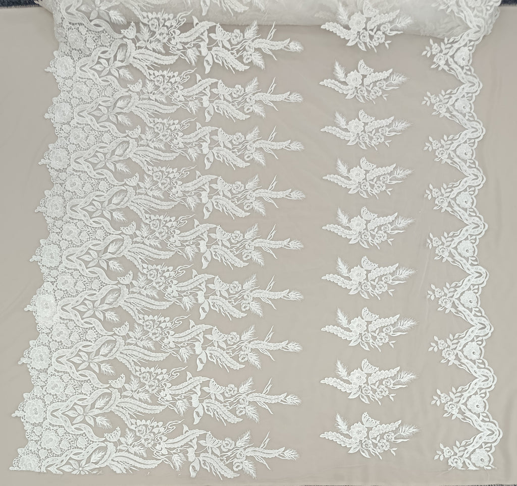 Detaliu broderie florală pe tul alb cu perle și pietre decorative.