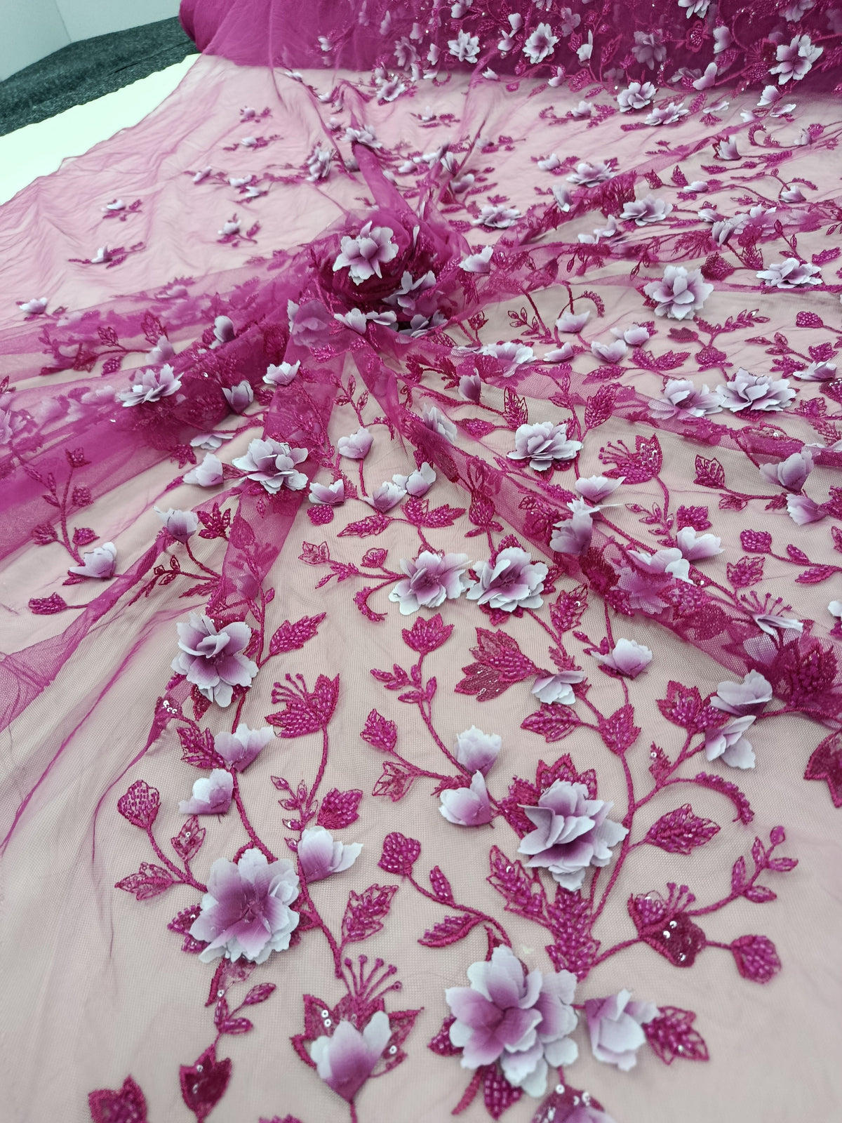 Prim-plan cu flori 3D și pietre tubulare pe material Fucsia