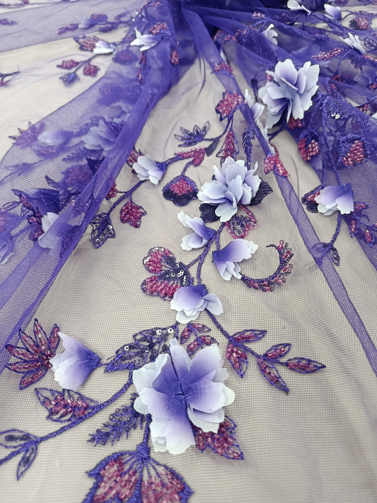 Prim-plan cu flori 3D și pietre tubulare pe material Violet