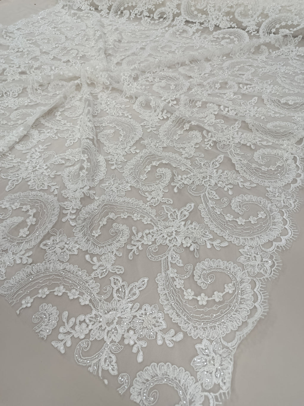 Detaliu broderie Paisley pe tull alb cu pietre de nisip și perle