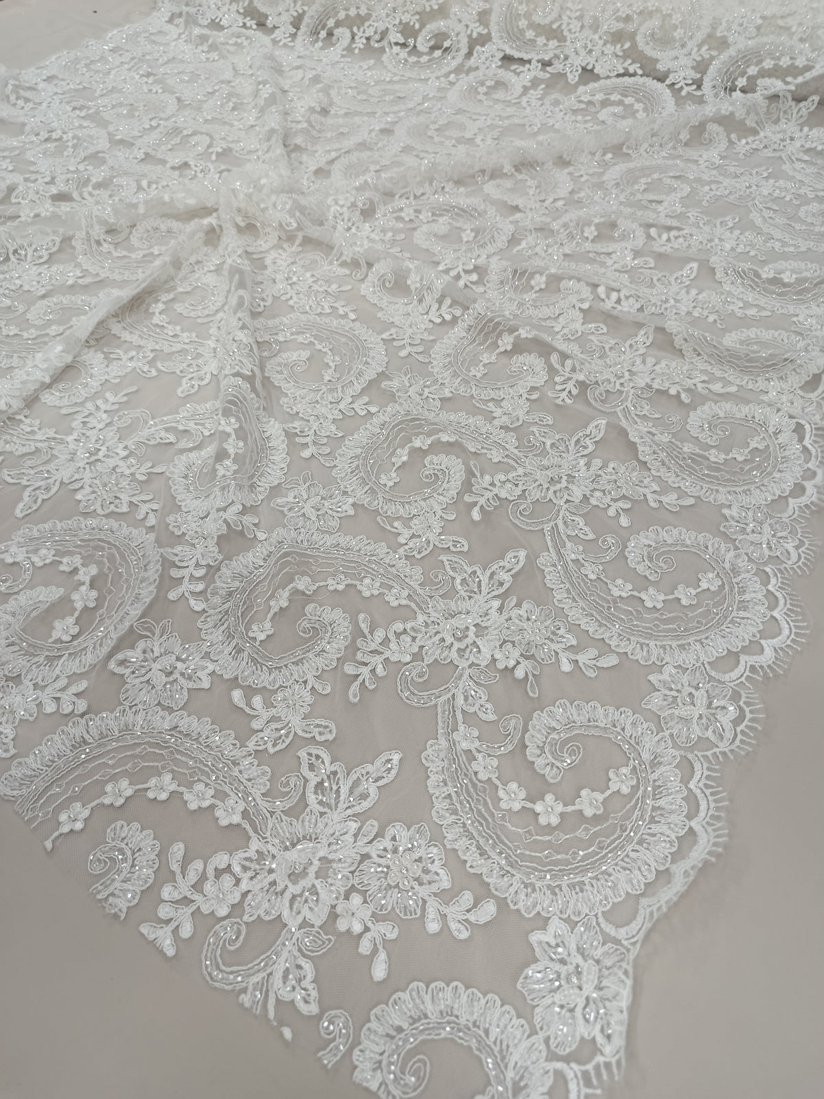 Detaliu broderie Paisley pe tull alb cu pietre de nisip și perle